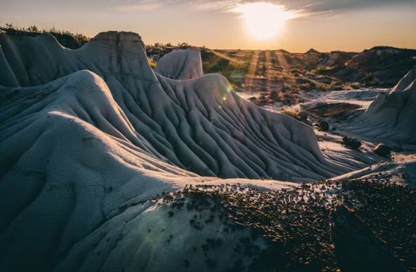 A sunset over the desert with some sand dunes
